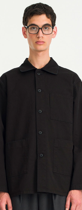 A man wearing a black button up Olive Shirt with glasses