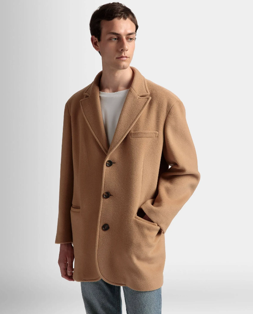 A man wearing a Bally brown overcoat