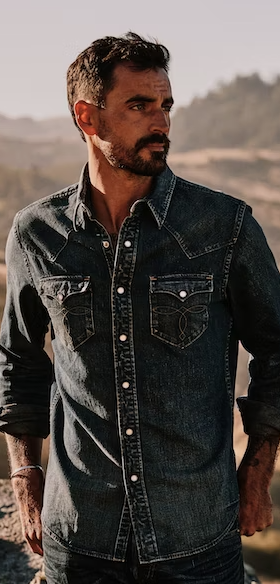 A man wearing a denim Huckberry western button up shirt