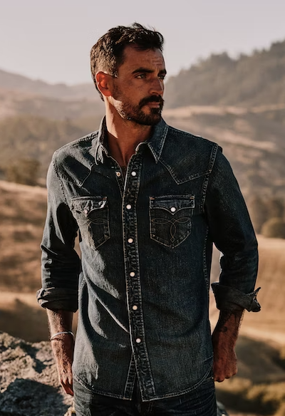 A man wearing a denim Huckberry western button up shirt