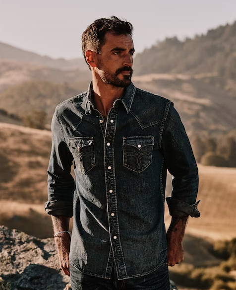 A man wearing a denim Huckberry western button up shirt
