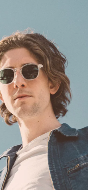 A man wearing a pair of light grey Sunski sunglasses