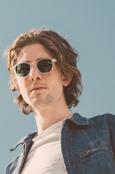 A man wearing a pair of light grey Sunski sunglasses