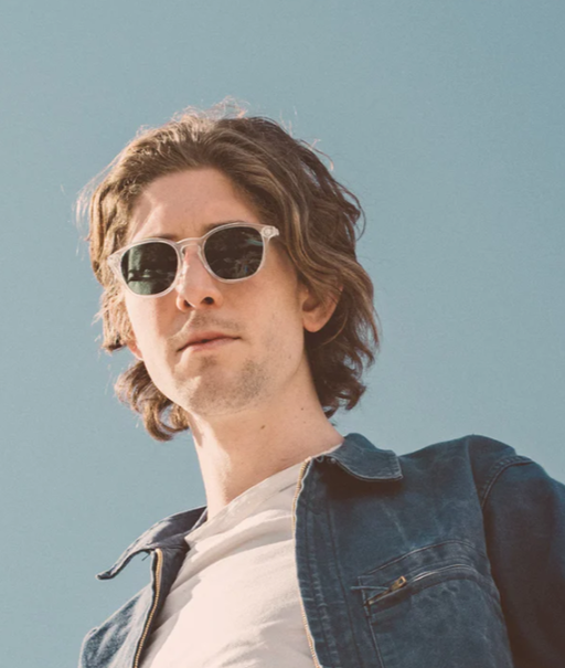 A man wearing a pair of light grey Sunski sunglasses