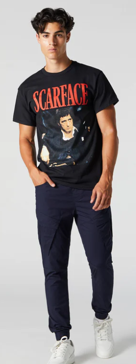 A man wearing an Urban Planet Scarface black t-shirt