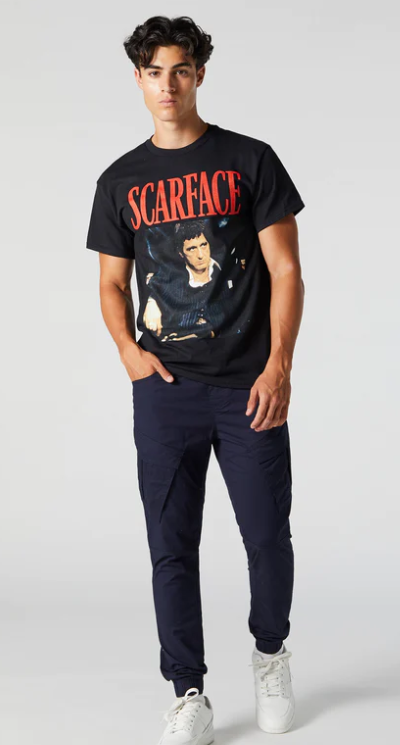 A man wearing an Urban Planet Scarface black t-shirt