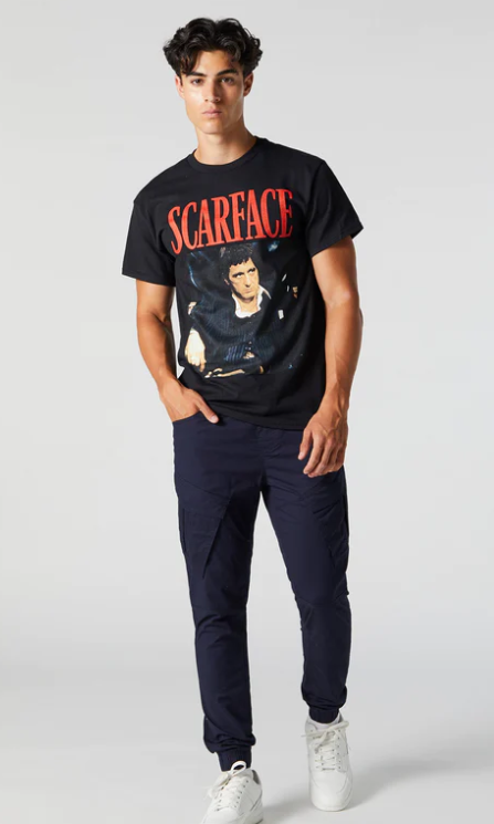 A man wearing an Urban Planet Scarface black t-shirt