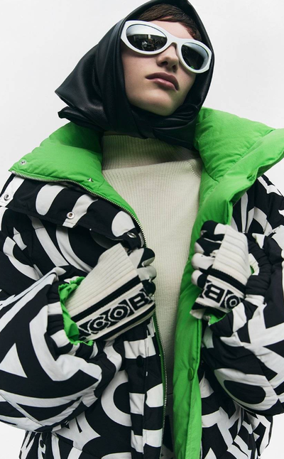 A woman wearing a colorful Marc Jacobs jacket with futuristic sunglasses
