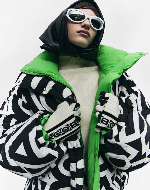 A woman wearing a colorful Marc Jacobs jacket with futuristic sunglasses