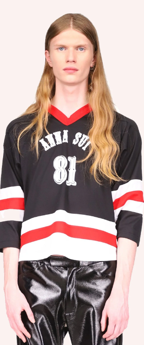 A man wearing a Anna Sui hockey jersey with leather black pants