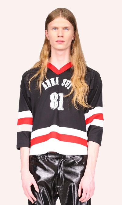 A man wearing a Anna Sui hockey jersey with leather black pants