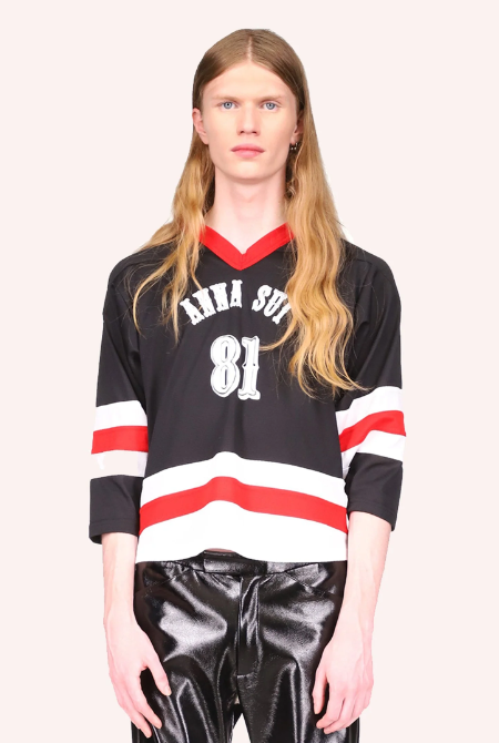 A man wearing a Anna Sui hockey jersey with leather black pants