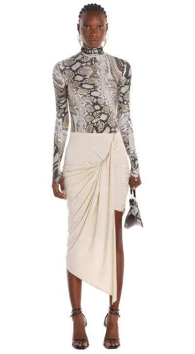 A woman wearing a crocadile print tight fitting Mugler shirt with a skirt