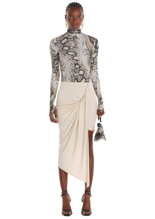 A woman wearing a crocadile print tight fitting Mugler shirt with a skirt
