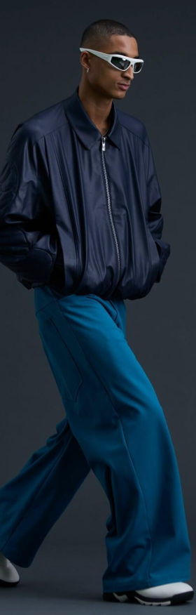 A man wearing a A. A. SPECTRUM black jacket and oversize pants