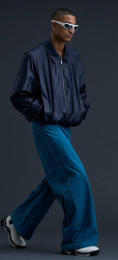 A man wearing a A. A. SPECTRUM black jacket and oversize pants
