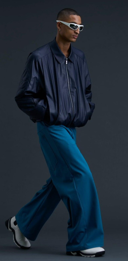 A man wearing a A. A. SPECTRUM black jacket and oversize pants