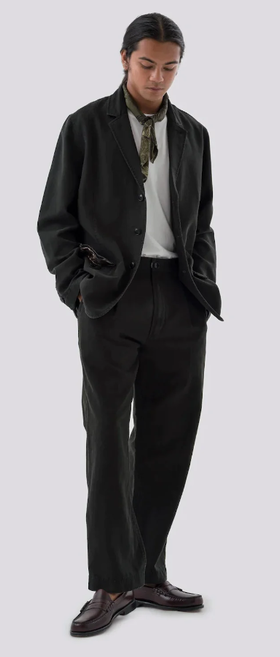 A man wearing a black Maharishi suit with a hankerchief