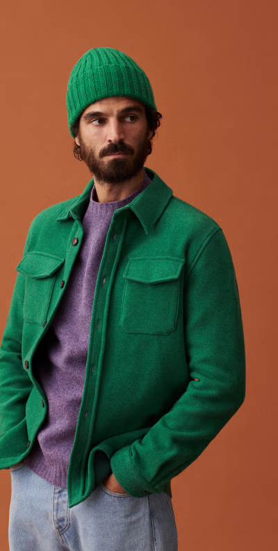 A man wearing a green Sezane jacket with matching beanie