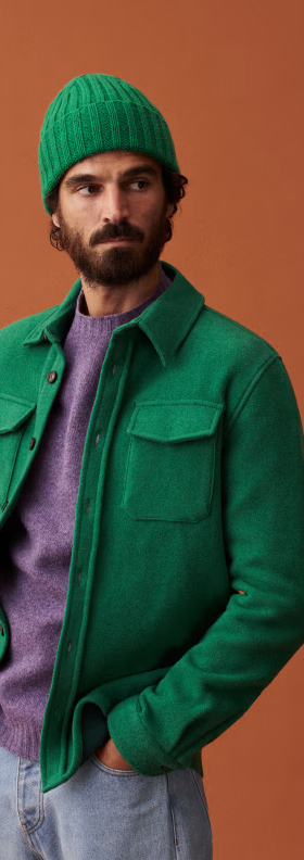 A man wearing a green Sezane jacket with matching beanie