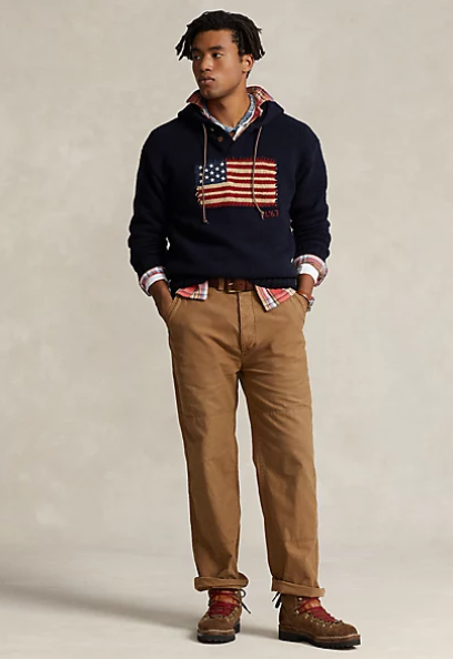 A man wearing a RRL USA flag hoodie with brown chinos