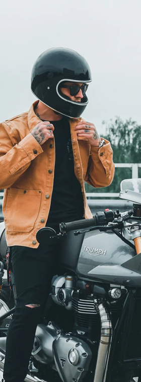 A man wearing a brown Floyd leather jacket while riding a motorcycle