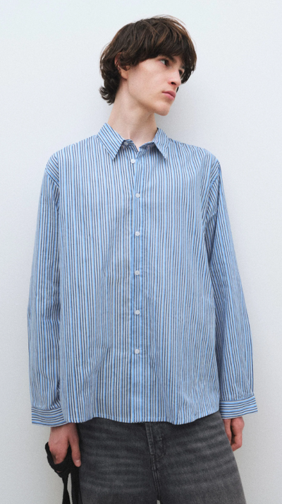 A man wearing a blue Gimaguas oxford button up shirt