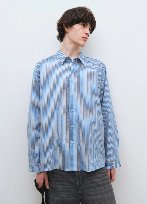 A man wearing a blue Gimaguas oxford button up shirt