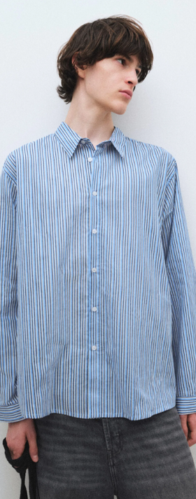 A man wearing a blue Gimaguas oxford button up shirt