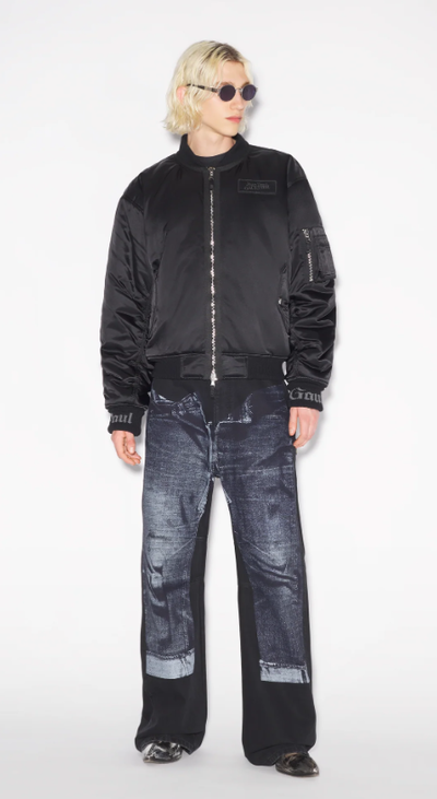 A man wearing a Jean Paul Gaultier black jacket and dark denim