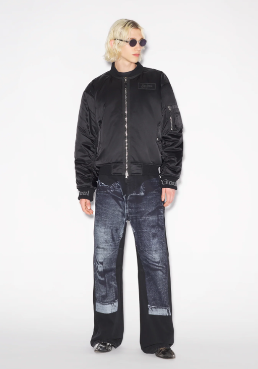 A man wearing a Jean Paul Gaultier black jacket and dark denim