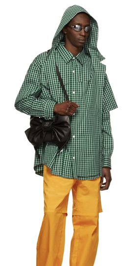 A man wearing a green checkered Hood By Air jacket and yellow pants