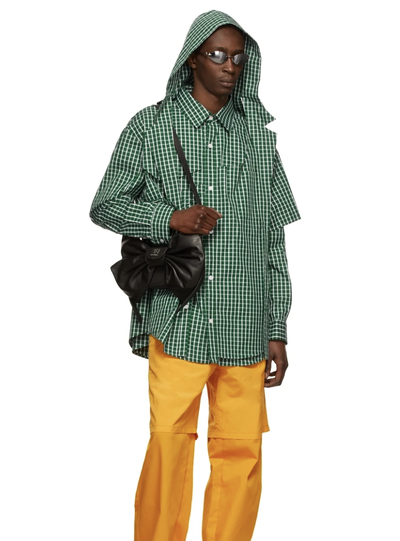 A man wearing a green checkered Hood By Air jacket and yellow pants