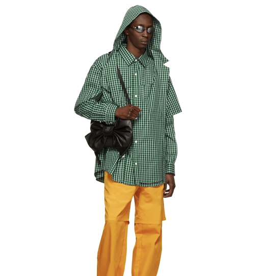 A man wearing a green checkered Hood By Air jacket and yellow pants