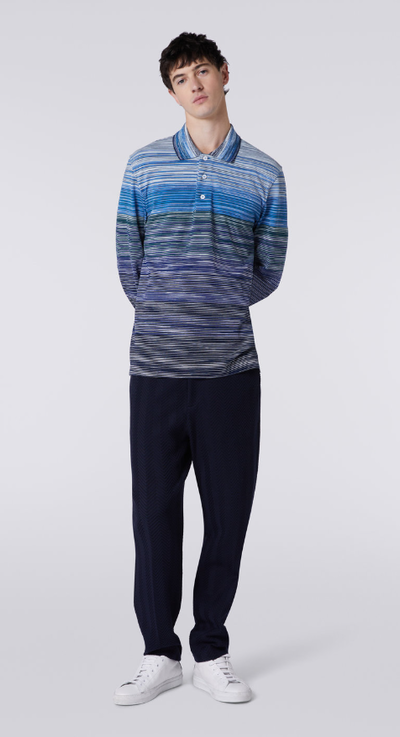 A man wearing a blue Missoni colored long-sleeve and black pants