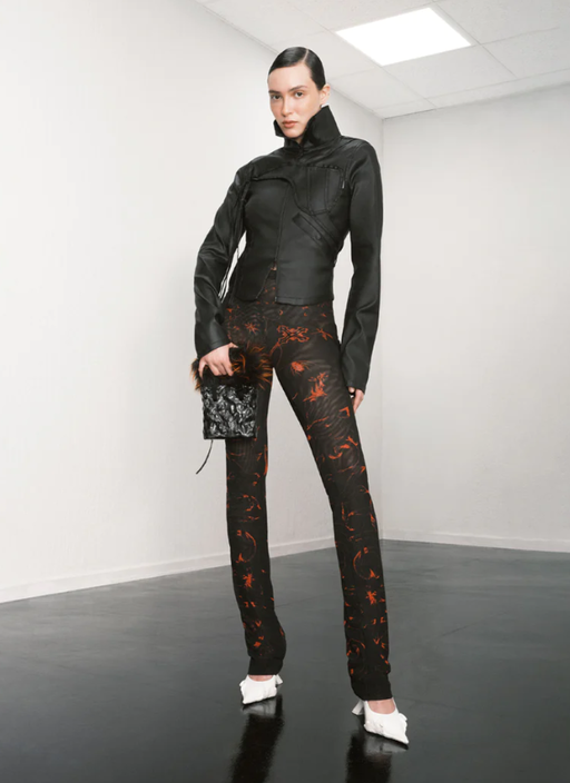 A woman wearing a tight fitting Ottolinger outfit in black with floral print