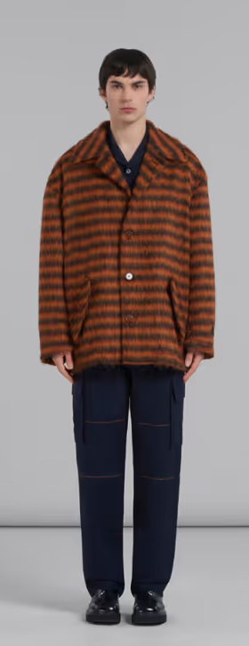 A man wearing a brown striped fleece overcoat by Marni with black pants