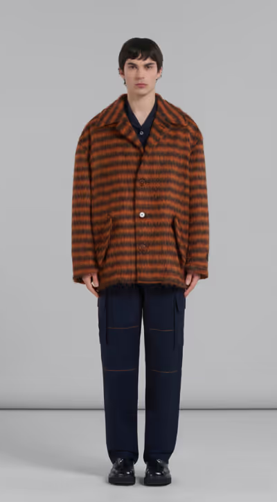 A man wearing a brown striped fleece overcoat by Marni with black pants