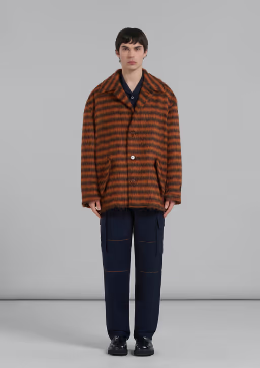 A man wearing a brown striped fleece overcoat by Marni with black pants