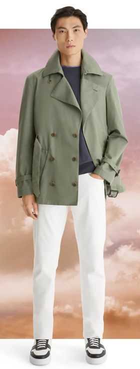 A man wearing a olive green Canali jacket with white pants and sneakers