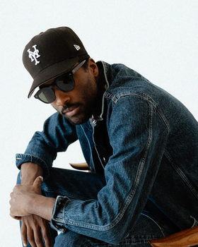 A man wearing a 3sixteen jacket and a black hat