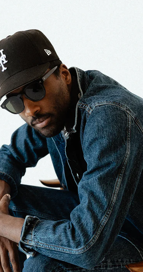 A man wearing a 3sixteen jacket and a black hat