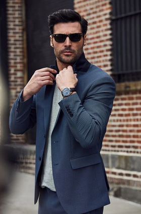 A man wearing a Bulova watch and a suit with sunglasses