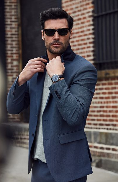 A man wearing a Bulova watch and a suit with sunglasses