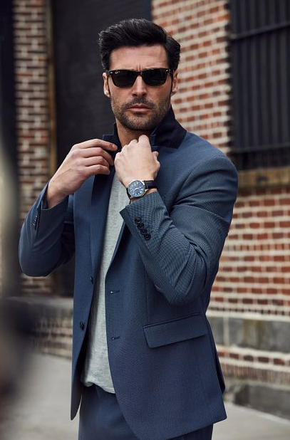 A man wearing a Bulova watch and a suit with sunglasses