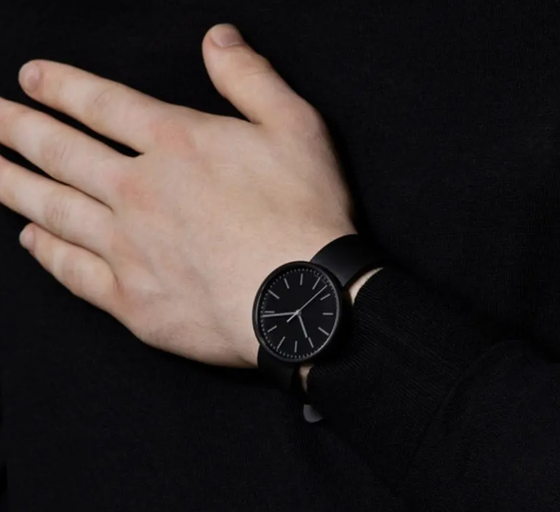 A man wearing a black Uniform Wares watch