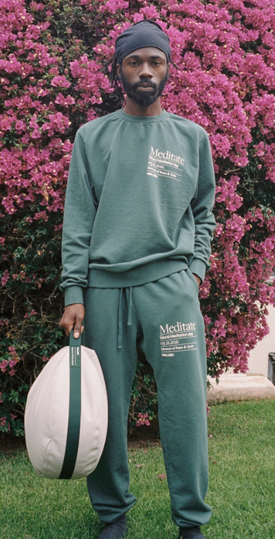 A man wearing a green MUSEUM OF PEACE AND QUIET sweatsuit