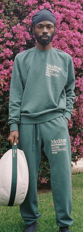 A man wearing a green MUSEUM OF PEACE AND QUIET sweatsuit