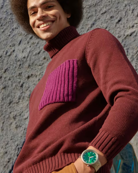 A man wearing a silver Swatch and a turtle-neck long-sleeve