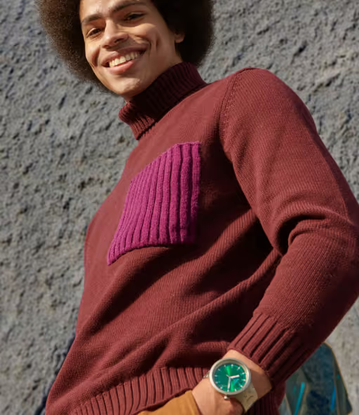 A man wearing a silver Swatch and a turtle-neck long-sleeve